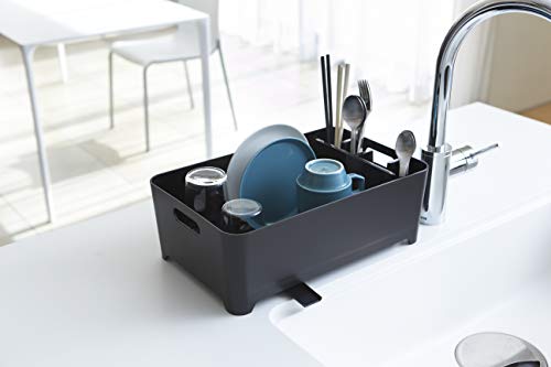 Escurreplatos compacto, diseño simple y elegante de Yamazaki, hecho de plástico negro, con percolador para el agua de enjuague, asas laterales y compartimento para los cubiertos.